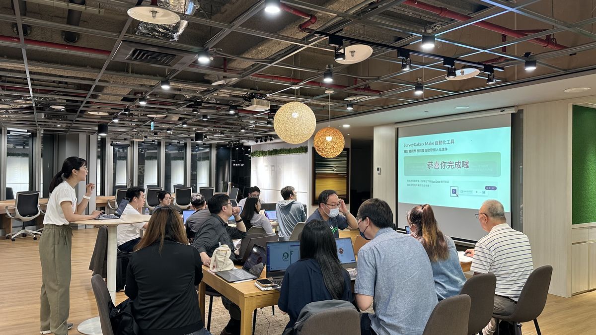 2025 年 6 月 SurveyCake 自動化應用工作坊現場，講師在學員座位間指導